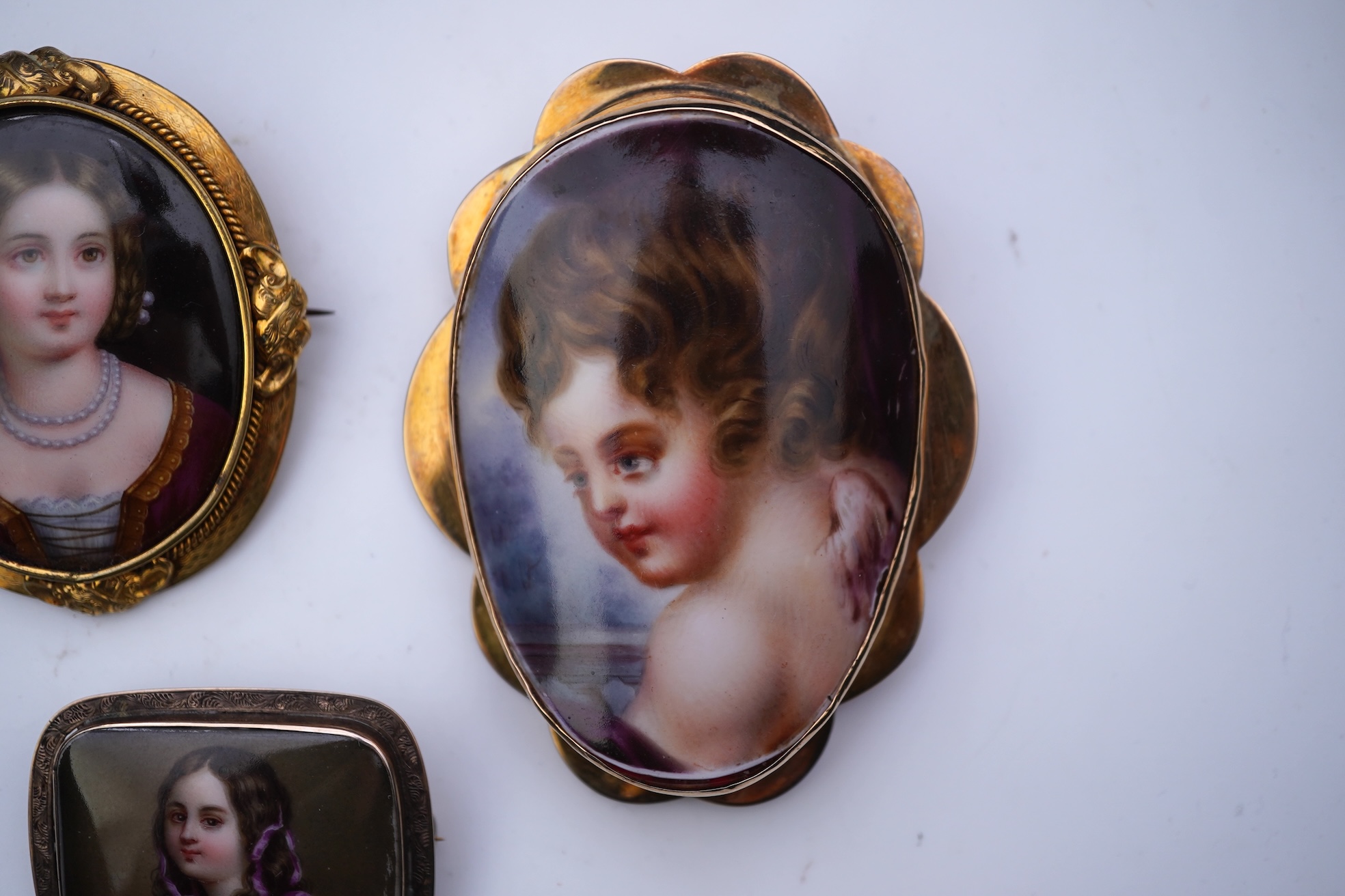 Three painted enamel brooches, mid 19th century
